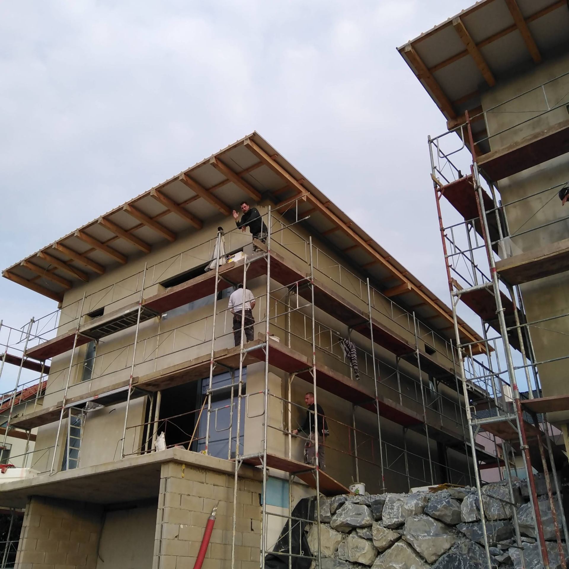 Cantilevered roof assembly and facade works on new construction.